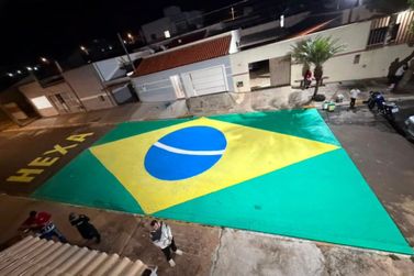 Moradores pintam bandeira do Brasil em rua do bairro Dom Bosco, em Rio das Pedras