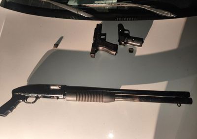 Cinco adultos foram detidos durante abordagem na madrugada. Arma estava carregada com sete cartuchos e escondida sob banco do motorista.
