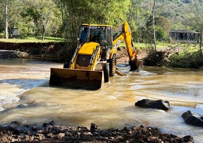 Trabalho retira &aacute;rvores e taquareiras que ca&iacute;ram no leito do rio e inclui, tamb&eacute;m, desobstru&ccedil;&atilde;o de bueiros na localidade.