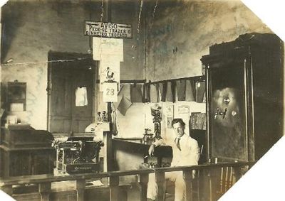 Imagem destaca o antigo m&eacute;todo de arquivamento em paredes, m&aacute;quina Remington e um aviso curioso para os clientes da &eacute;poca.