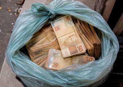 Morador encontrou uma sacola com 111 c&eacute;dulas de R$ 50 dentro de uma lixeira na cal&ccedil;ada de casa. Dinheiro estava molhado e parte das notas tinha rasgos