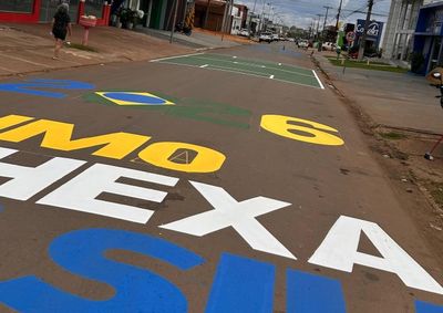Comerciantes se antecipam ao mundial e pintam o asfalto com frases de incentivo e campos de futebol para resgatar a paix&atilde;o nacional