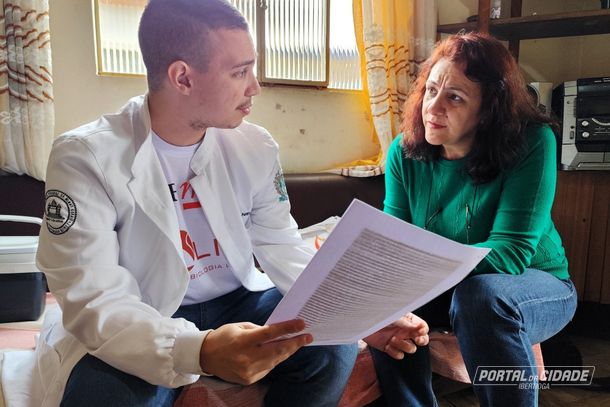 O imunologista Lucas Ventura explica para a sobrinha de dona Lenita, Andr&eacute;ia Rodrigues,o documento sobre a participa&ccedil;&atilde;o no projeto DNA Longevo
