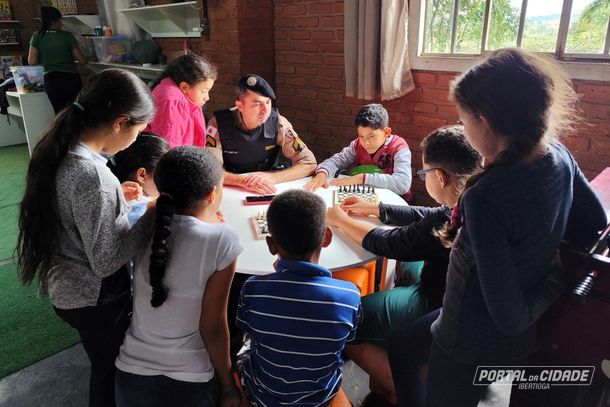 Alunas e alunos em volta da mesa para ouvir as explica&ccedil;&otilde;es de Zaneti