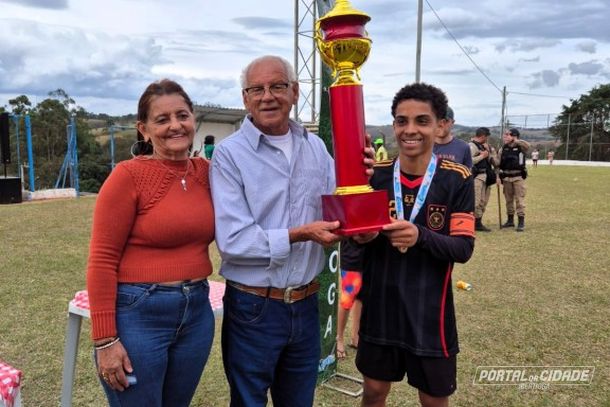 Ta&ccedil;a de campe&atilde;o entregue pelo homenageado, Ant&ocirc;nio Pereira e a esposa, Josefina Freitas, ao jogador Isaque