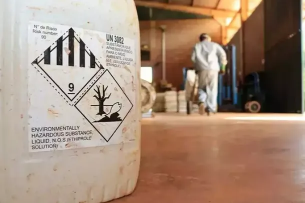 Ao fundo, t&eacute;cnico manuseia embalagens de agrot&oacute;xicos (Foto: Osmar Veiga).... veja mais em https://www.campograndenews.com.br/reportagens-especiais/veneno-adoeceu-aldeia-contaminou-o-pantanal-e-virou-negocio-para-o-pcc-em-2025