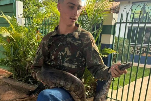 Jovem posa com a jiboia resgatada em frente &agrave; base da PMA em Jardim (Foto: Afonso Proni)