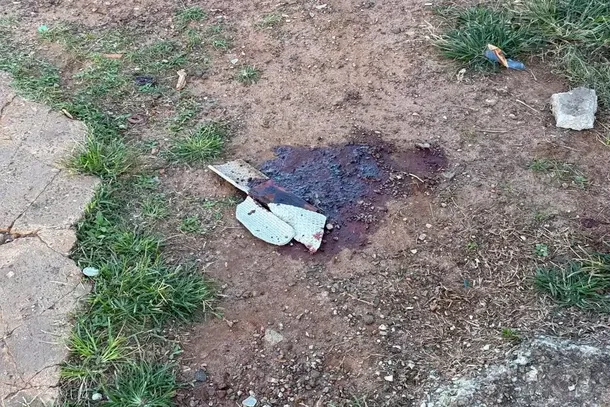 Sangue da v&iacute;tima e peda&ccedil;o de telha quebrada no local onde crime ocorreu (Foto: Vict&oacute;ria Costacurta)