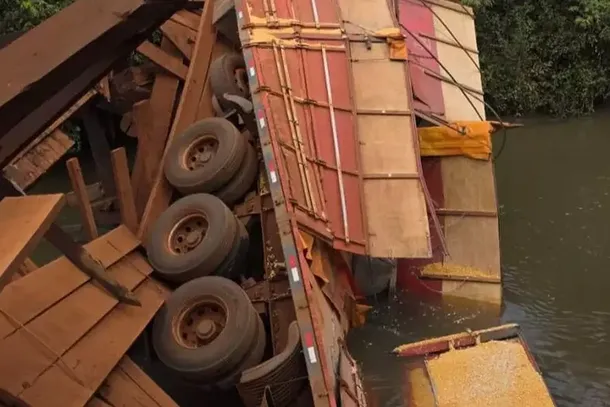 Com a quebra da estrutura, caminh&atilde;o tombou e ficou parcialmente dentro do rio (Foto: Banalizando MS)