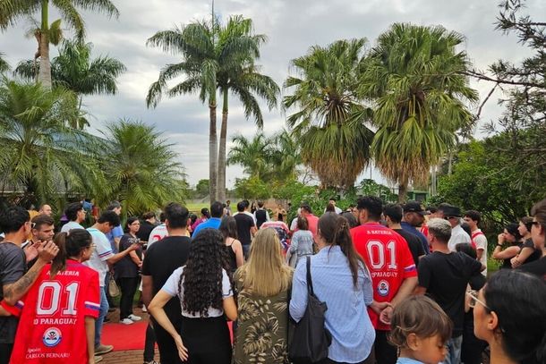 Caix&atilde;o de Lucas da Silva Mendon&ccedil;a, enrolado na bandeira da atl&eacute;tica do curso de Medicina, e amigos ao redor (Foto: Inez Nazira)