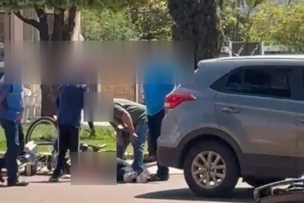 A v&iacute;tima ao solo com populares antes da chegada da equipe do Corpo de Bombeiros