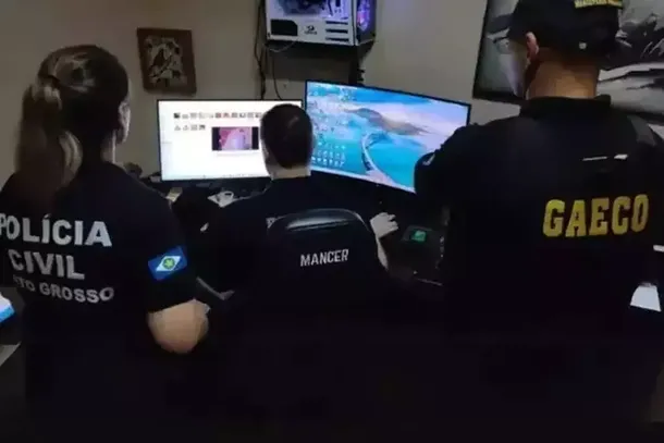 Policiais analisam dados armazenados em computador durante uma das fases da Opera&ccedil;&atilde;o Inf&acirc;ncia Segura, deflagrada pelo Minist&eacute;rio P&uacute;blico. (Foto: Arquivo/MPMS)