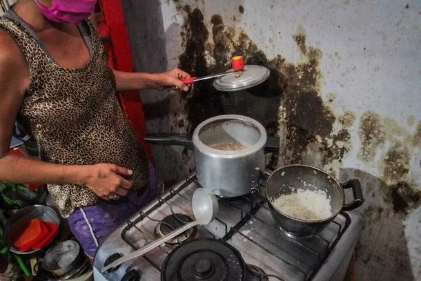 Moradora da Cidade de Deus mostrando as panelas de comida quase vazias. (Foto: Arquivo/Marcos Maluf)