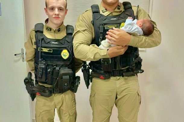 Foto do beb&ecirc; e dos policiais que ajudaram no momento do desespero.