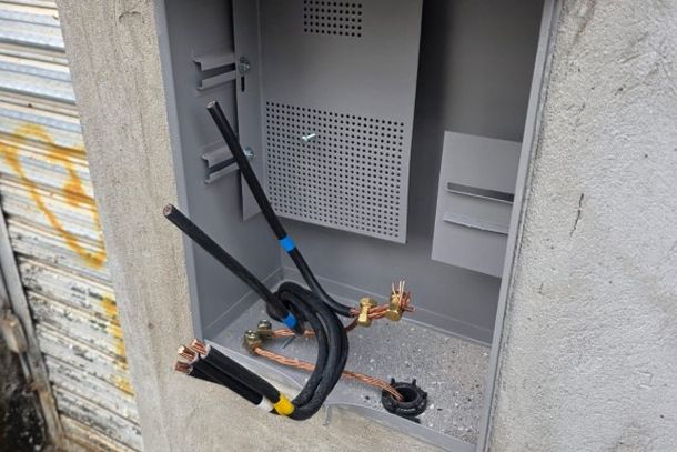 Fios arrancados e a caixa de energia danificada retratam os preju&iacute;zos deixados pelo furto de cabos no dep&oacute;sito.