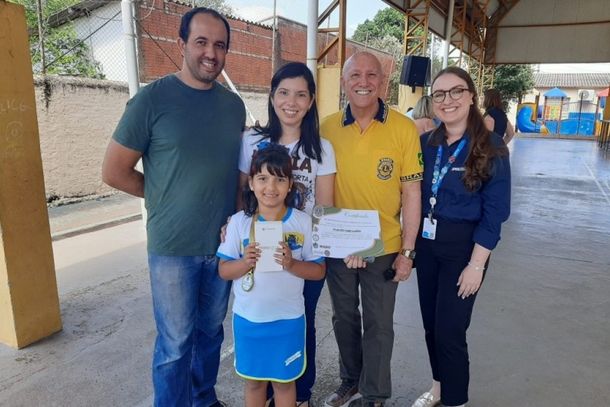 Da esquerda para a direita: Vinicius e Daniele Pasqualotto, Carlos Roberto Ramos Rodrigues (Lions) e Bianca Caroline Silva, da Sanessol, junto com a aluna J&uacute;lia Fiel Pasqualotto, ganhadora de um celular 