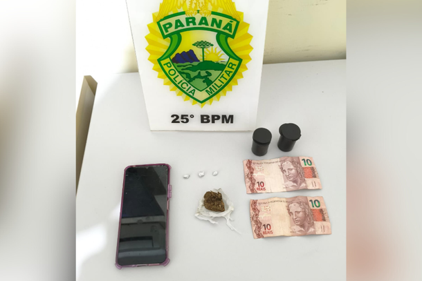 Na bolsa do suspeito foram encontradas 3 pedras de crack (0,7 g), 5,9 g de maconha em potes, R$ 20 e um celular