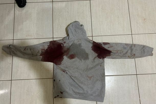 Roupa da v&iacute;tima com vest&iacute;gios de sangue, apreendida pela PM